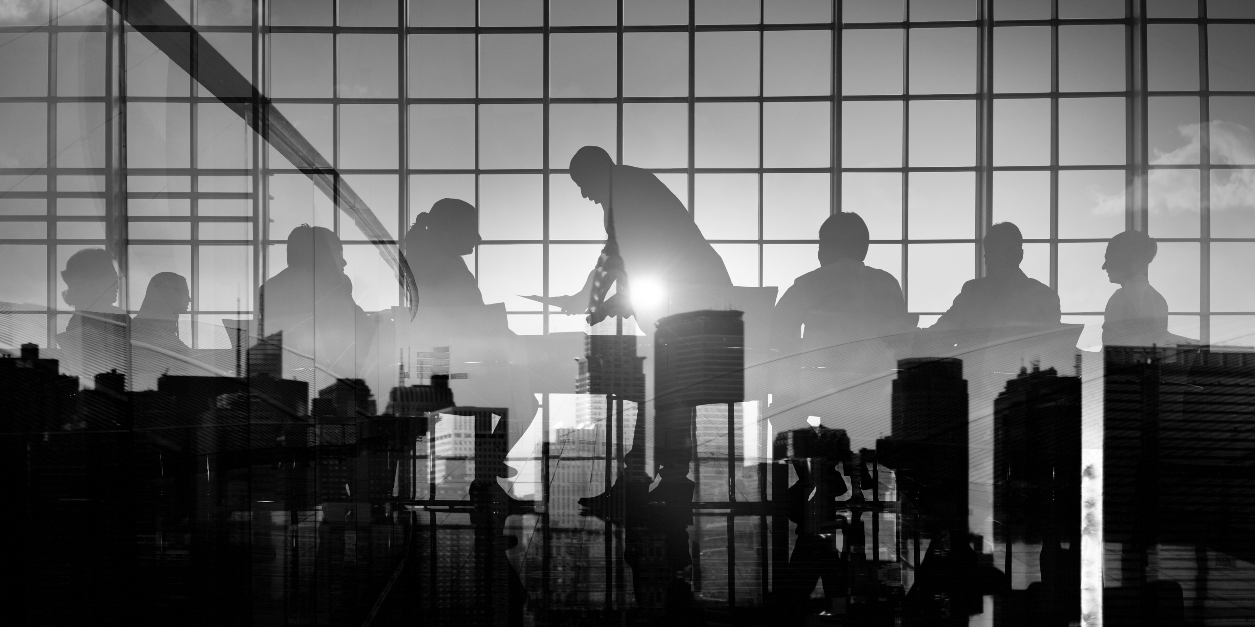 Business team silhouettes in meeting with cityscape background